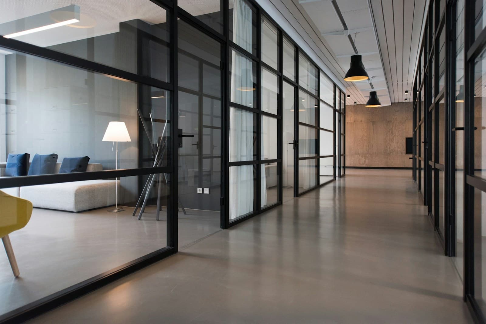 A clear office corridor with open rooms and a path forward